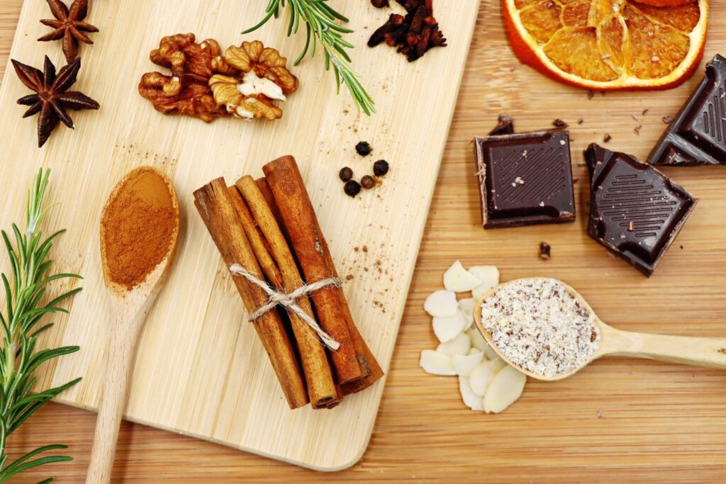Mörk choklad, rosmarin och kryddor arrangerade på skärbrädor
